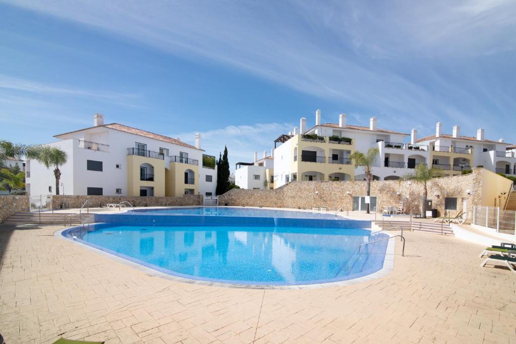 a large swimming pool in front of some buildings at O'pomar 150 in Tavira