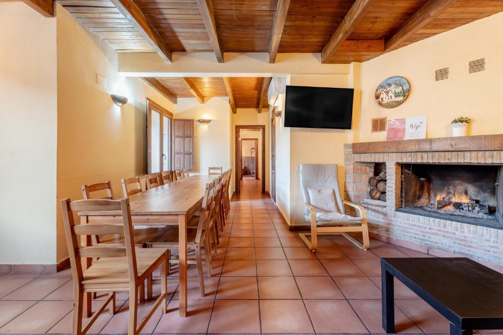 a dining room with a table and a fireplace at La Posada in Chera