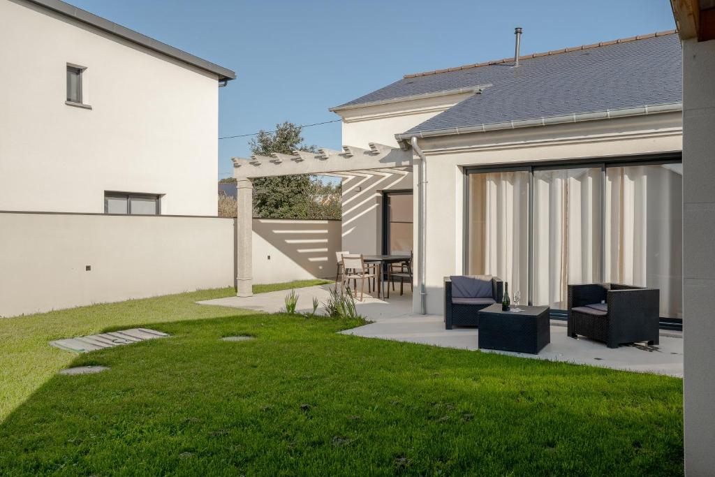 a backyard with two chairs and a lawn at Maison avec jardin proche Dinan in Trévron