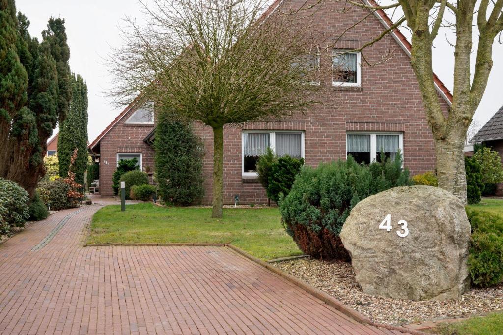 a brick house with a large rock in front of it at Fewo Kaiser in Südbrookmerland