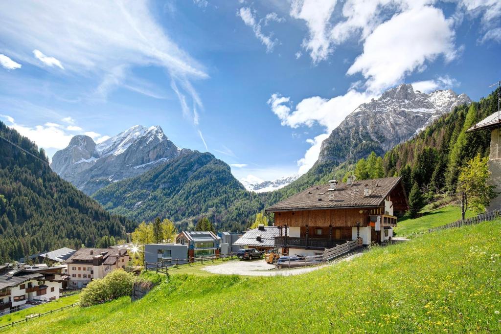 a village in a valley with mountains in the background at Appartamenti Camilla in Canazei