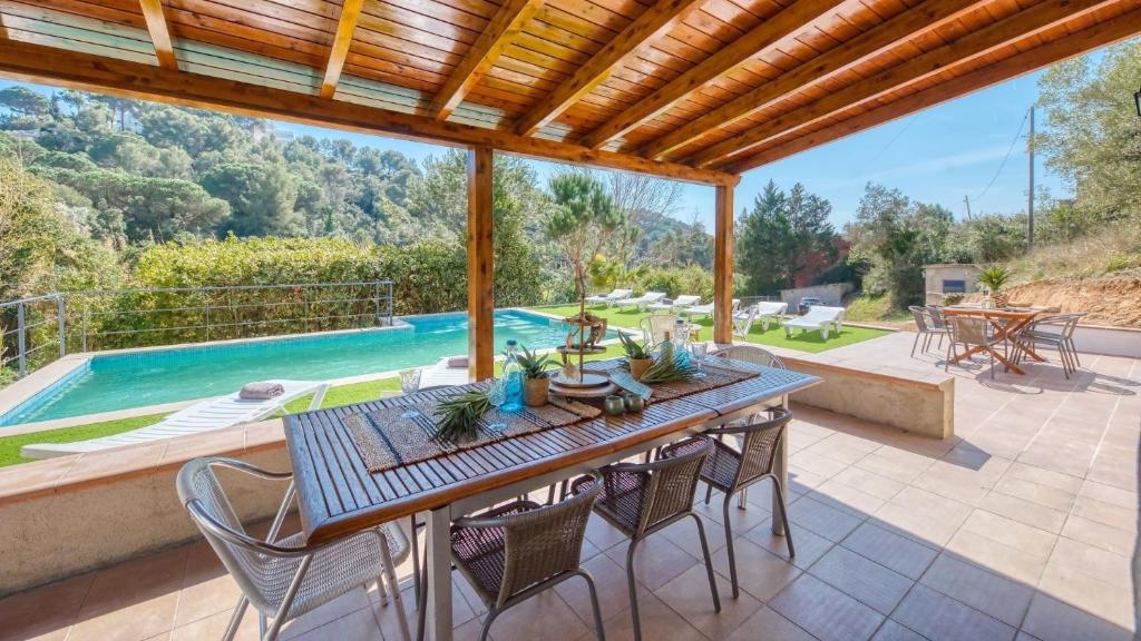 an outdoor patio with a table and chairs and a swimming pool at Costacabana - Villa Pilar in Lloret de Mar