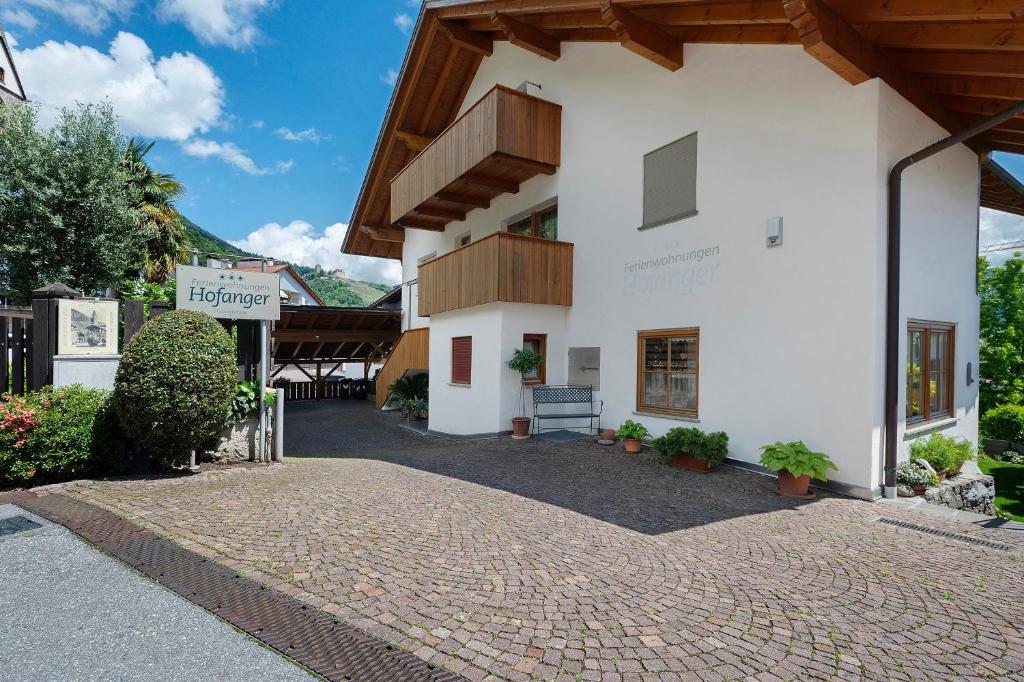a large white building with a brick driveway at Hofanger in Lagundo