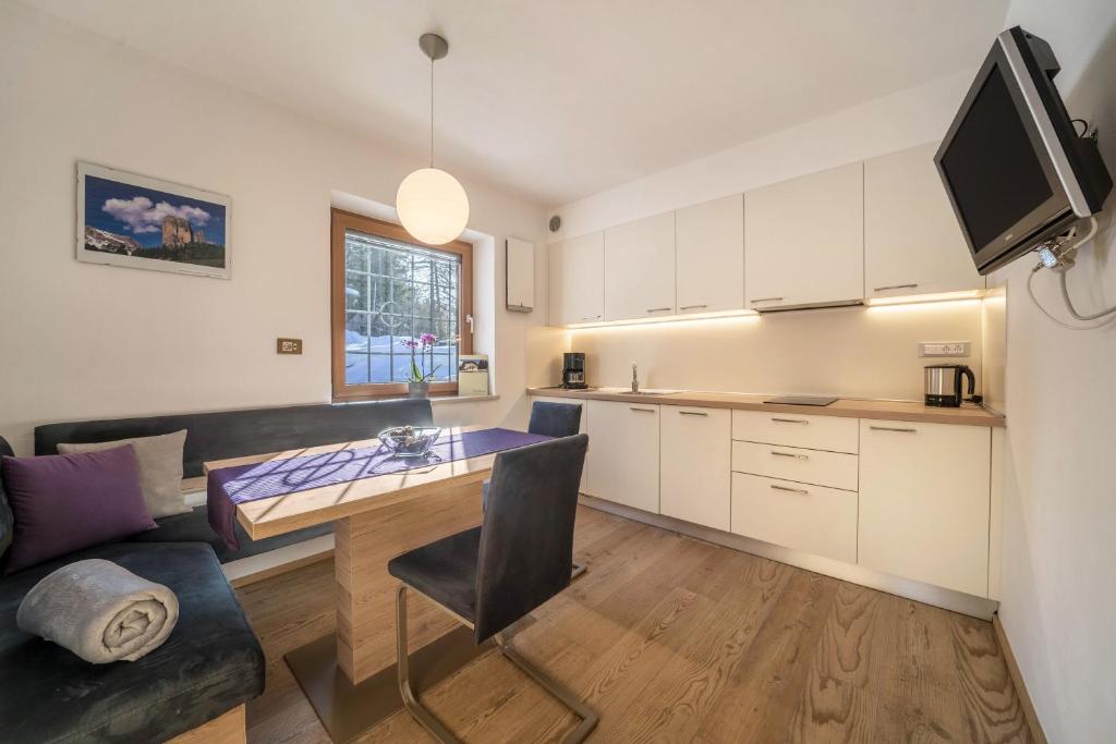 a kitchen and living room with a table and a couch at Ferienwohnung Hirzer Edelweiss in Avelengo