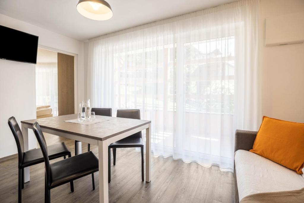 a dining room with a table and chairs and a couch at Apartment Treï Residence Bun Ste in San Vigilio Di Marebbe