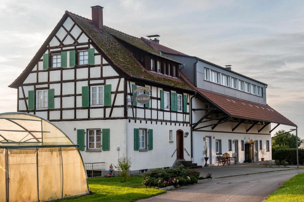 a large white building with a brown roof at Pension Zum Talhof in Reichenau