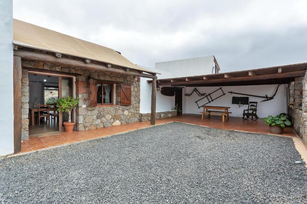 a stone house with a patio and a table at La Casilleta in Betancuría