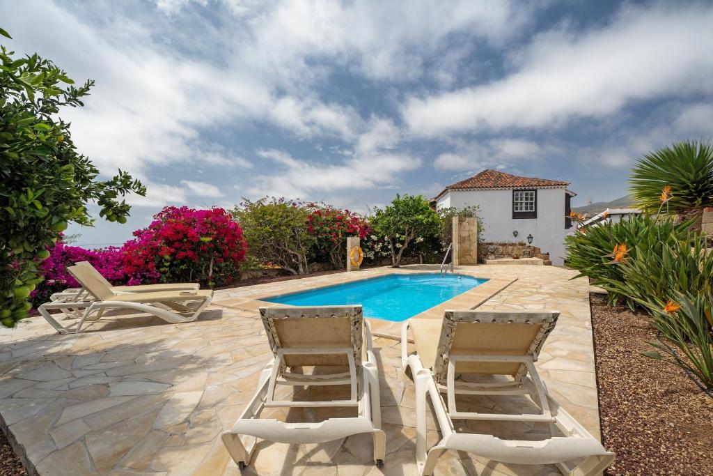 a patio with two chairs and a swimming pool at La Tunera in La Cisnera