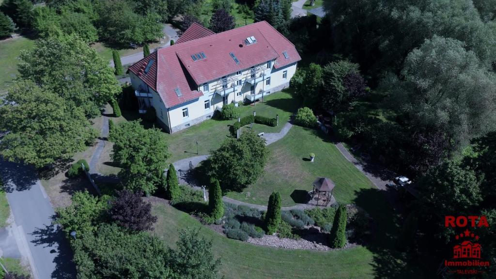an overhead view of a large white house with a red roof at Herrenhaus Carolinenhof in Groß Plasten