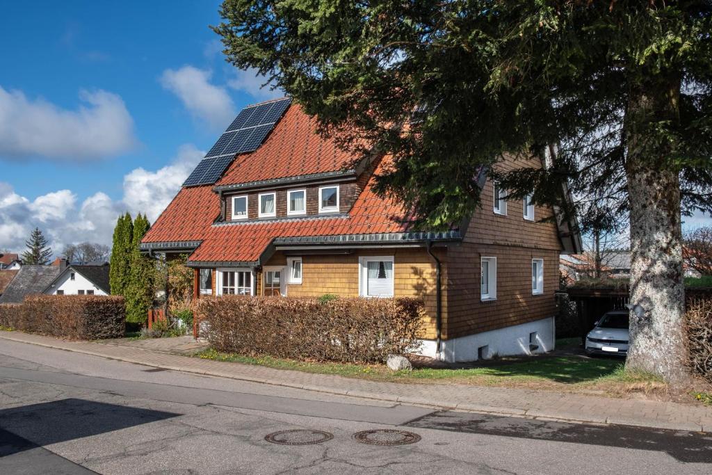 a house with an orange roof with a car parked in front at Hirschenhäusle in Sankt Märgen