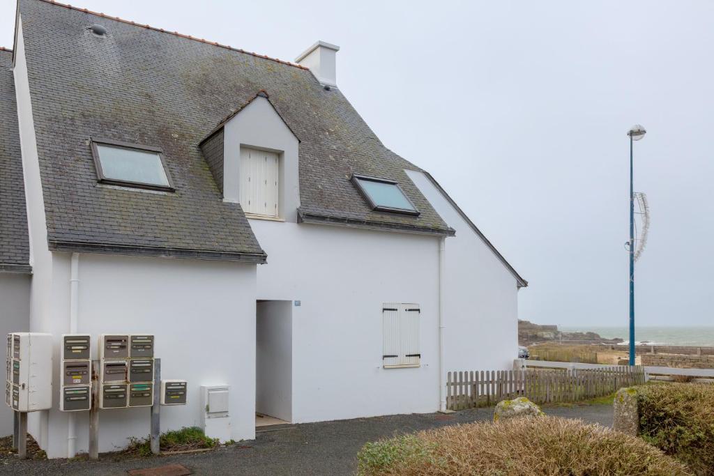 a white house with a gray roof at Appartement Guillaume vue mer in Trégunc