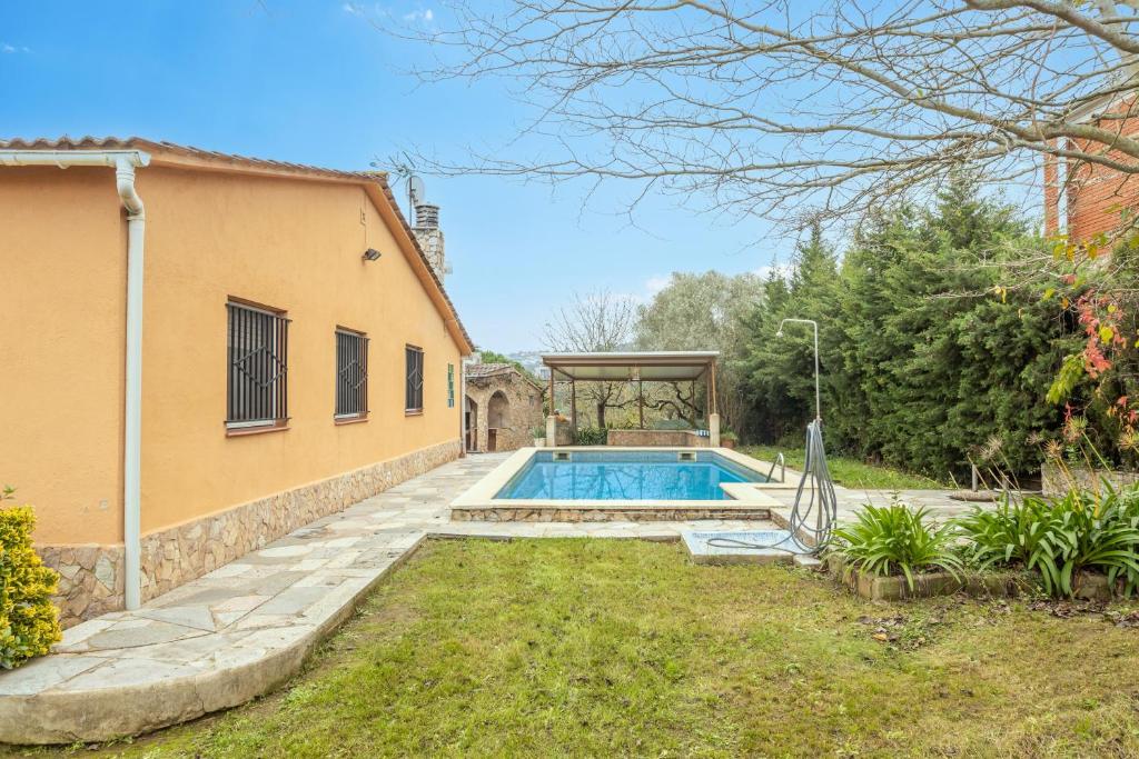 a pool in a yard next to a house at Casa Raymond con piscina in Maçanet de la Selva