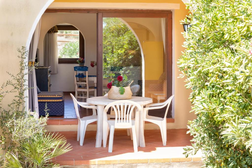 a patio with a table and chairs on a porch at Trilocale Fiordaliso in Stintino