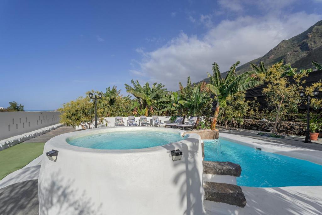a swimming pool in a resort with mountains in the background at Finca Oasis Samuel in Garachico
