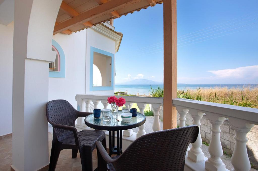 a balcony with a table and chairs and a view of the ocean at Apartment Vorrisi in Alykes