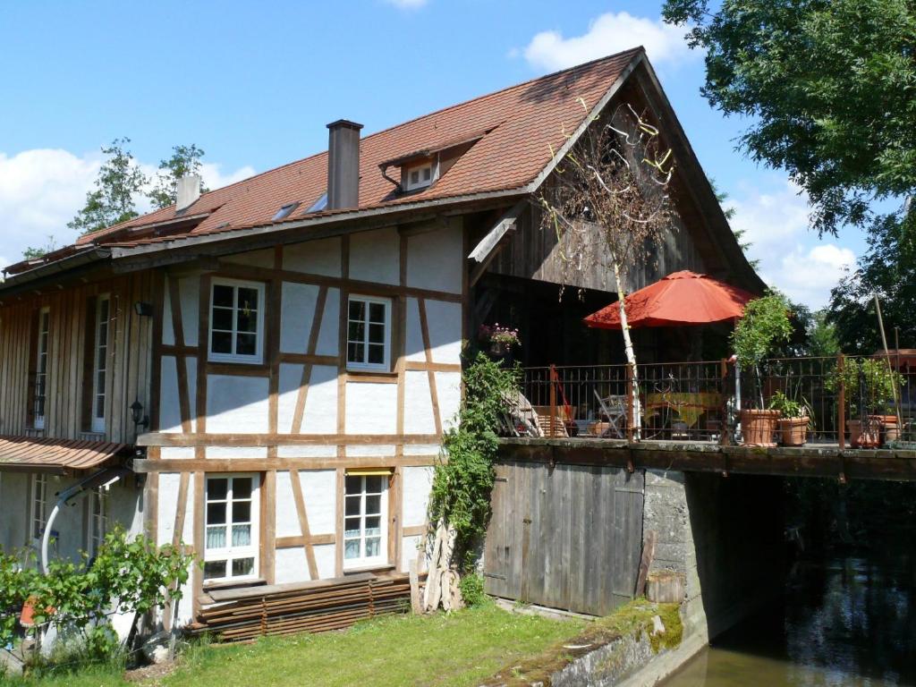 an old house with a bridge and an umbrella at Alte Wassermühle in Salem