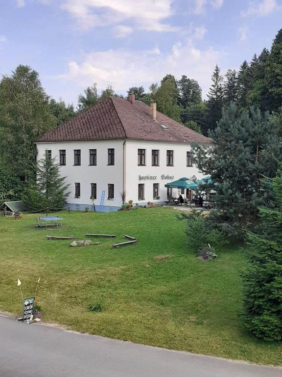 a large white house with a large yard in front of it at Penzion Bobas in Jindřichŭv Hradec