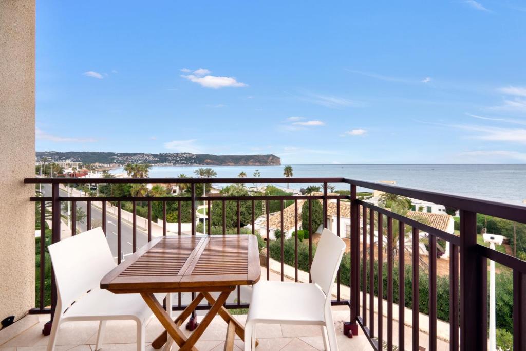 a balcony with a table and chairs and the ocean at Javea Brisas Del Mar Cofisa in Jávea