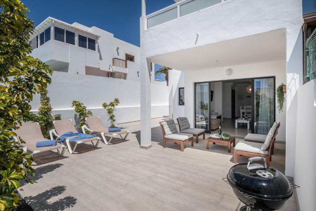 a patio with a bunch of chairs and a large building at Alegria in Puerto del Carmen