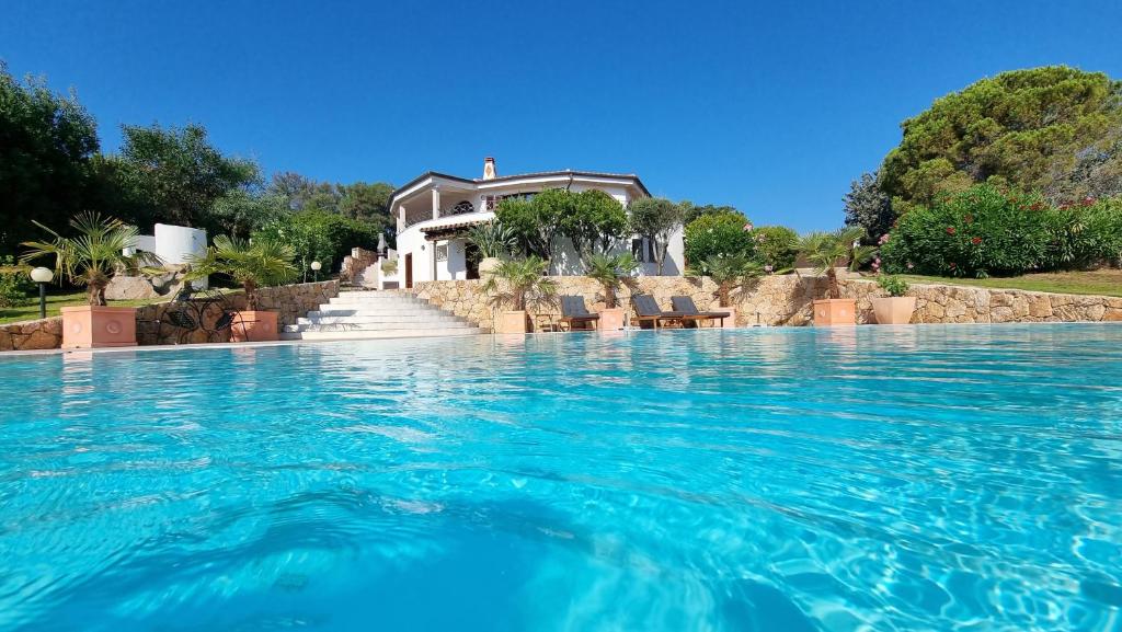 a large swimming pool with a house in the background at Villa Luna Rossa con piscina in San Teodoro
