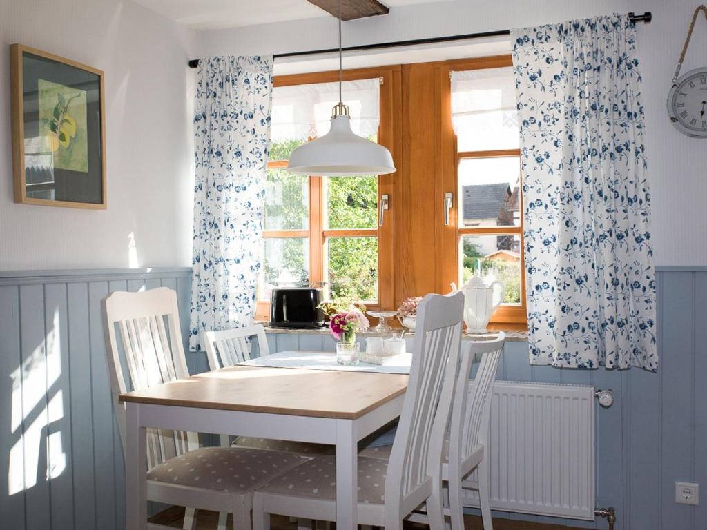 a dining room with a table and chairs and a window at Fachwerktraum im Hof in Alheim
