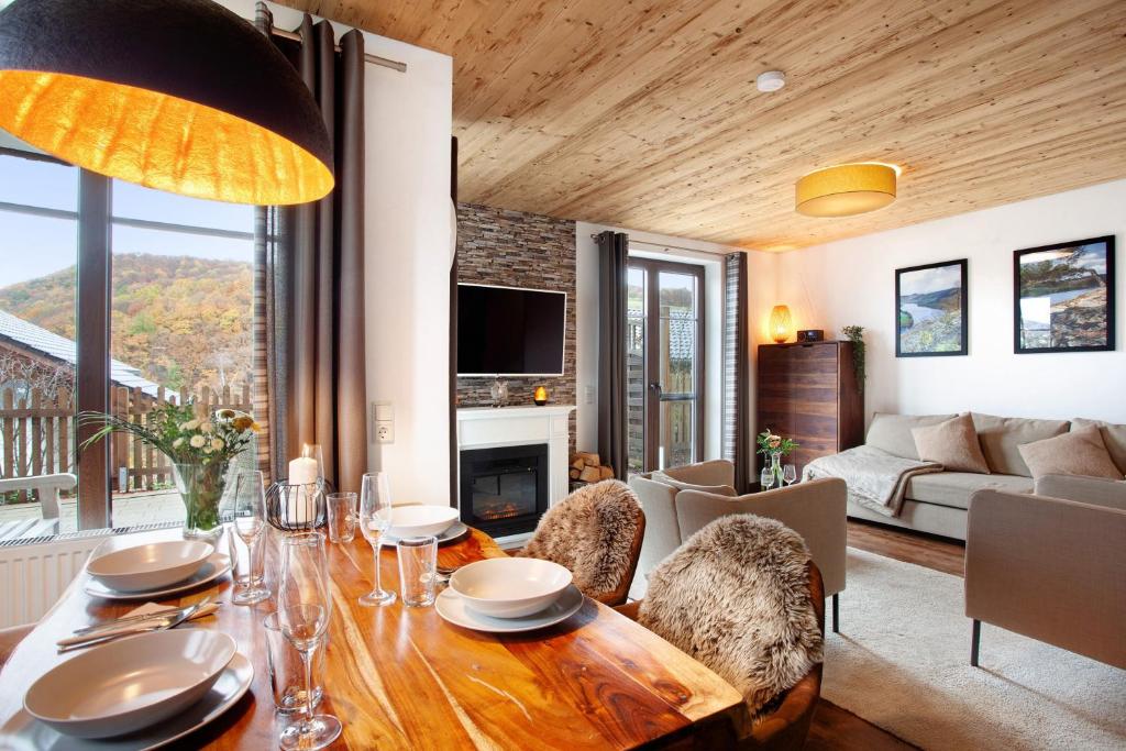 ein Wohnzimmer mit Tisch, Stühlen und Sofa in der Unterkunft Bergchalet 20 mit Sauna in Heringhausen