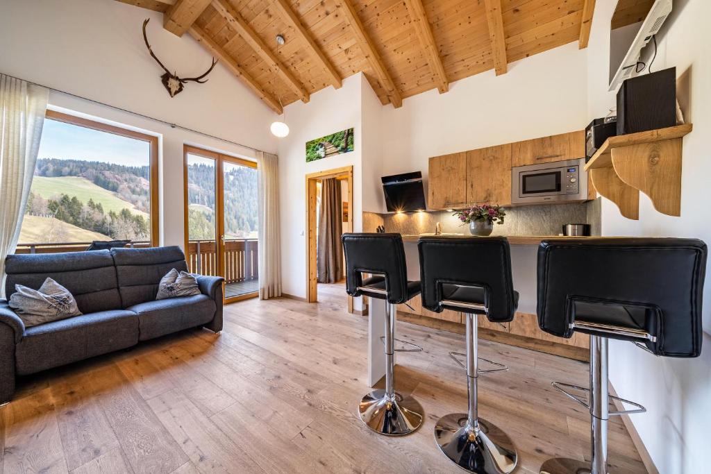 un soggiorno con divano e cucina di Eggerhof Suite a Verano