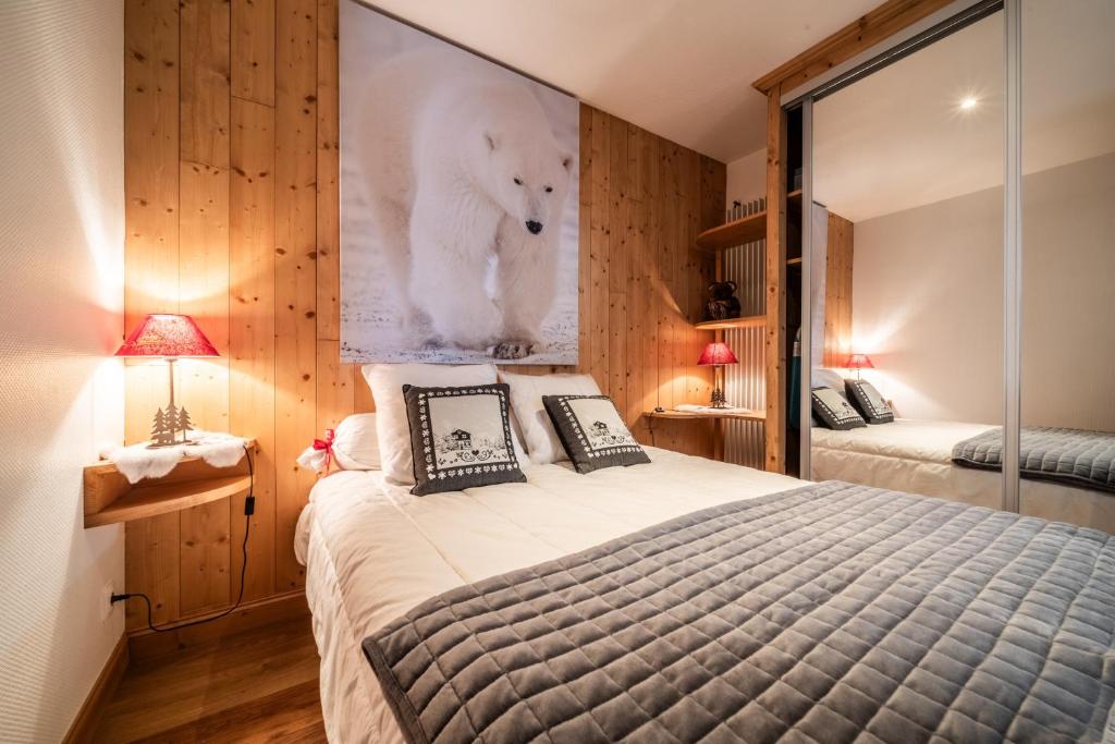 a bedroom with a large bed with a picture of a bear on the wall at Au Rêve Savoyard 3 - 6 personnes in Morillon