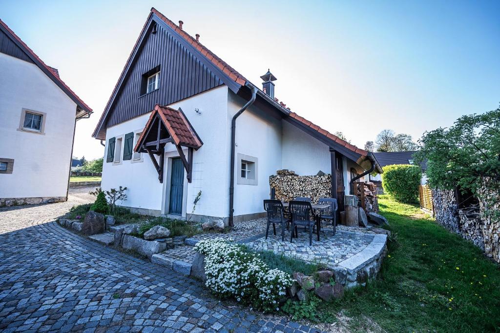 a house with two chairs and a table outside at Mühlenhof in Olbersdorf