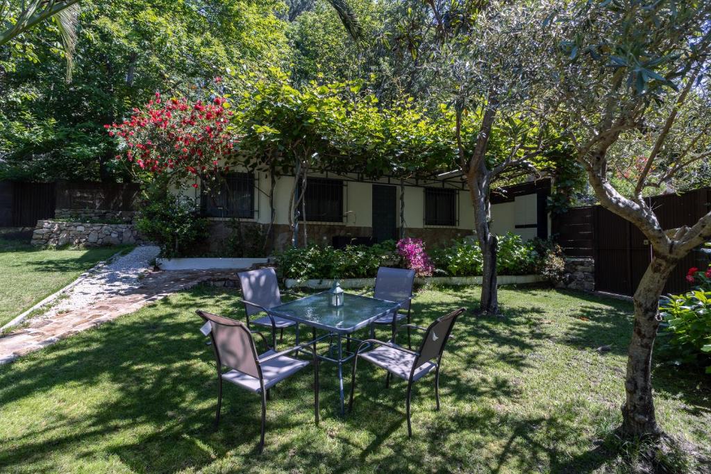 a patio with a table and chairs in a yard at El Castañar de Ceubia in Arenas de San Pedro