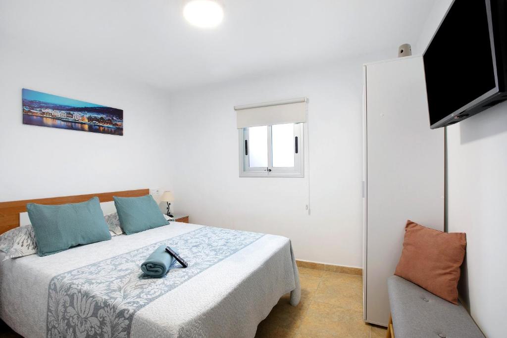 a bedroom with a bed and a television and a chair at Apartamento La Morena 3a in El Pris