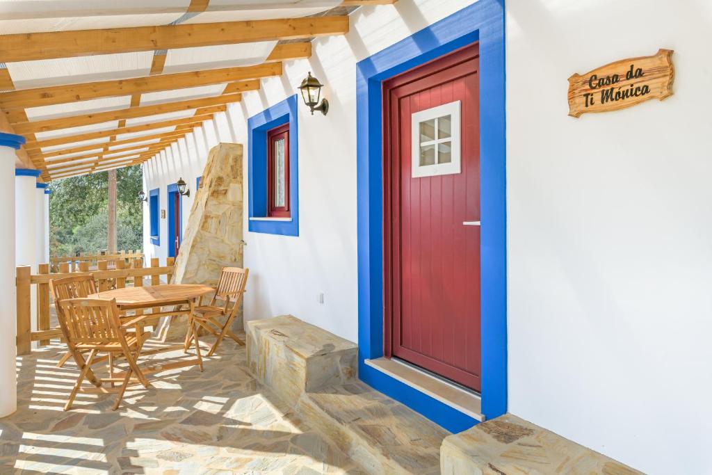 a red door on a house with a table and chairs at Casa da Ti Mónica in São Luis