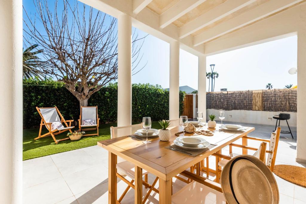a wooden dining table and chairs on a patio at Marce in Ciutadella