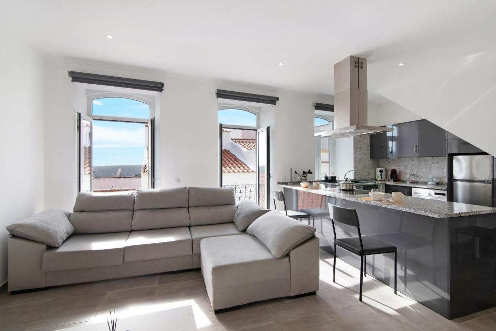 a living room with a couch and a kitchen at Traditional 3 bedroom apartment in Alte