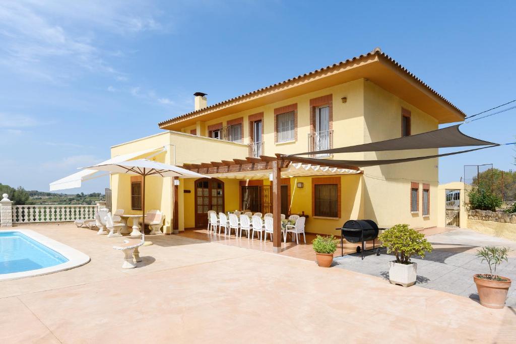 a villa with a swimming pool and a house at Cal Vimon in Las Masucas