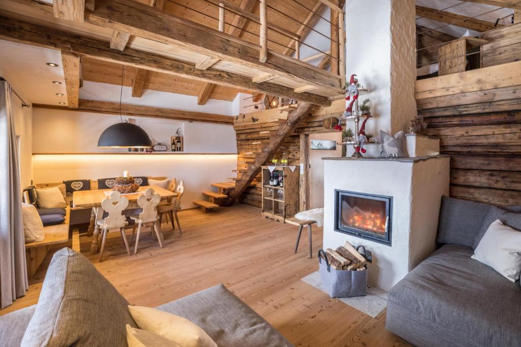 a living room with a fireplace and a table at Obereggeralm in Valdaora