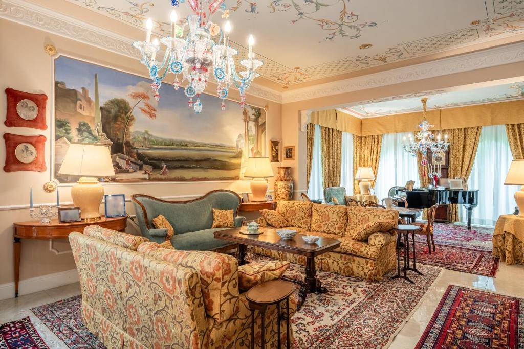 a living room with couches and a chandelier at Villa Manuela Flat in Chiesina Uzzanese
