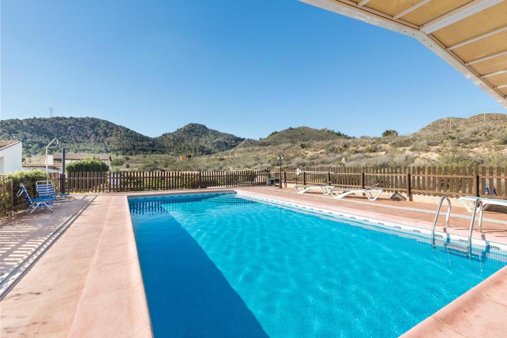 a swimming pool with mountains in the background at Finca Liarte in Murcia