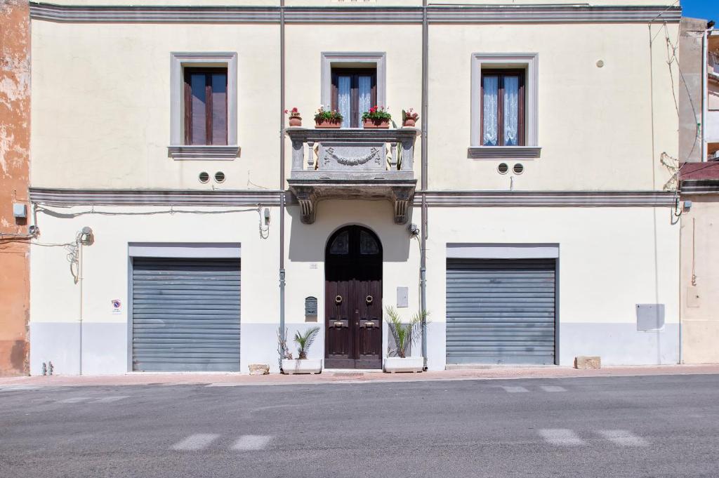 a building with three garage doors and a door with a balcony at Il Conte e La Contessa in Sennori