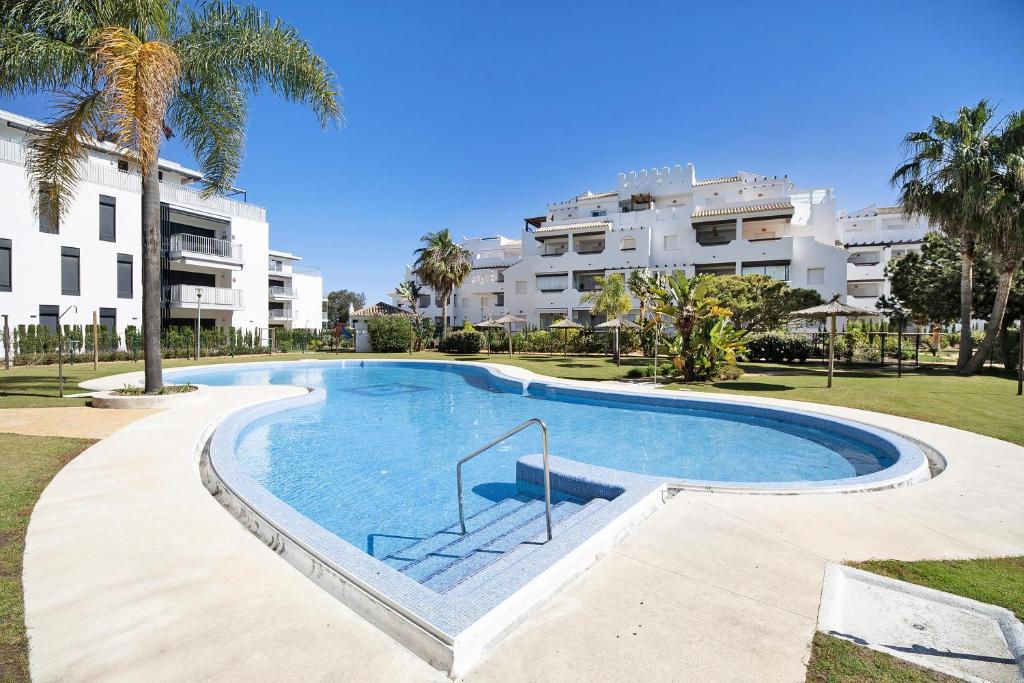 a large swimming pool in front of a building at Apartamento Punta Candor in Rota