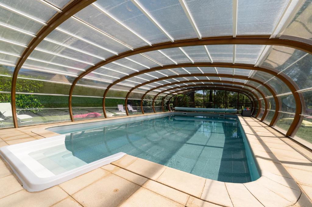 an indoor swimming pool with a glass ceiling at Domaine de Lestroué - Belle-île in La Vraie-Croix