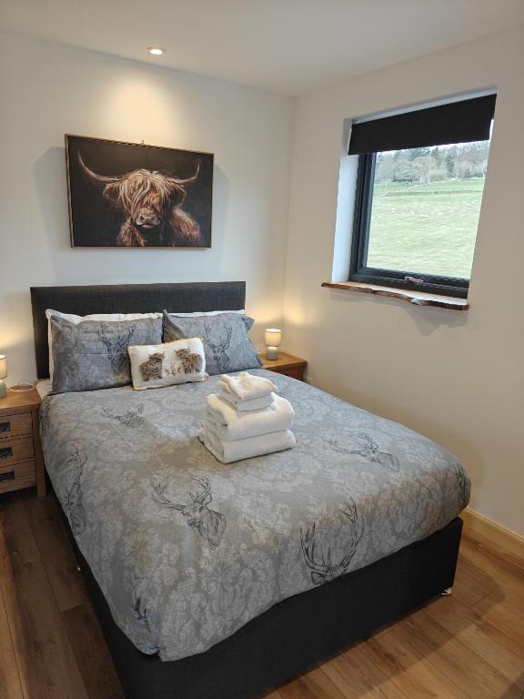 a bedroom with a bed with two towels on it at Temuka Lodge in Glenurguhart