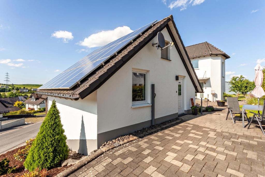 a white house with solar panels on the roof at Ferienhaus Am Brande in Schmallenberg