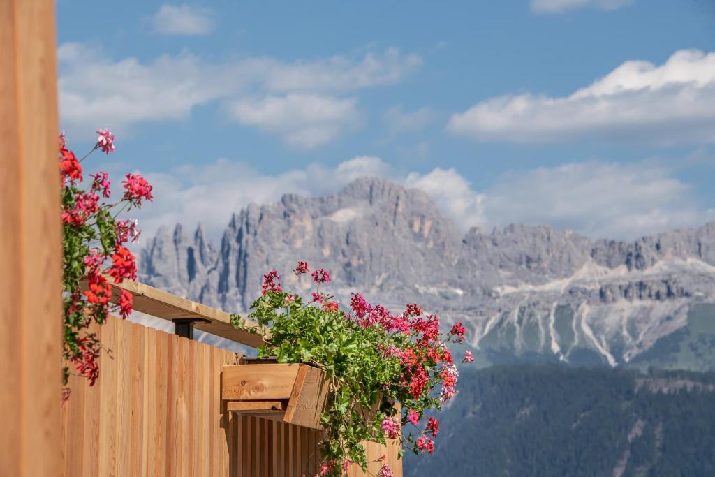 a fence with flowers on it with a view of mountains at Furnerhof Apt Olpenglühn in Collepietra