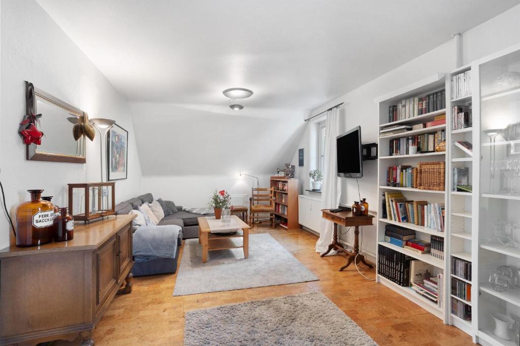 a living room with a couch and book shelves at Schöne Dachgeschoss Wohnung in Warstein
