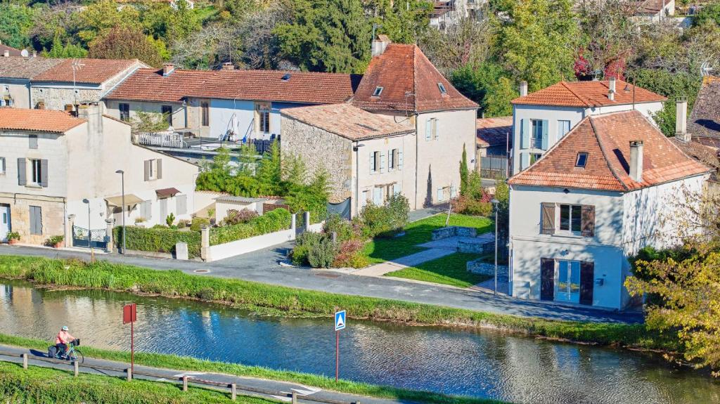a village next to a river with houses at Maison Séjour Capraisien in Saint-Capraise-de-Lalinde