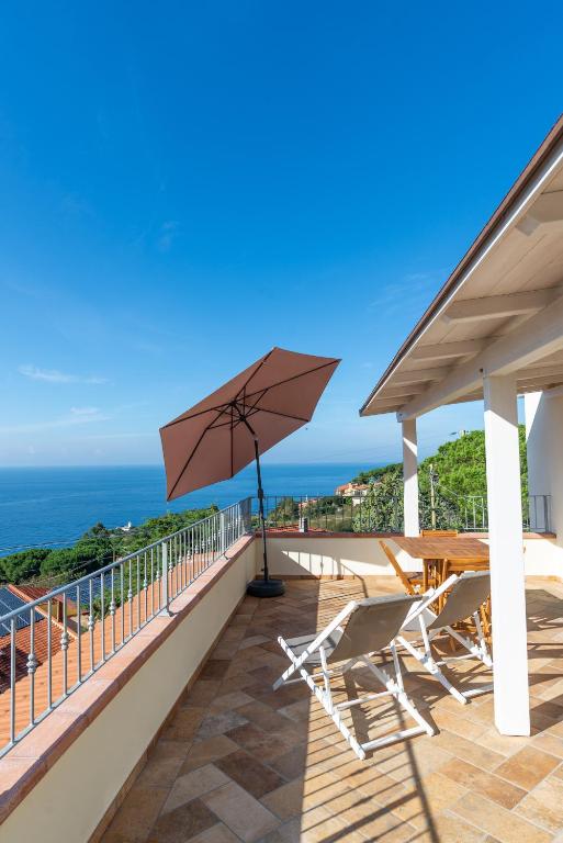 a patio with a table and chairs and an umbrella at L' Elicriso in Marciana