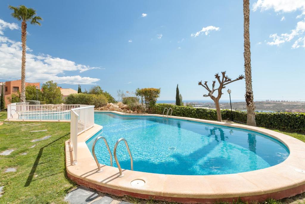 a swimming pool in a yard with palm trees at El Mirador in Mutxamel