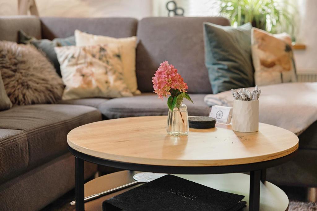 a coffee table with a vase of flowers on it at Ferienhaus Alte Wognerei in Fuchsmühl