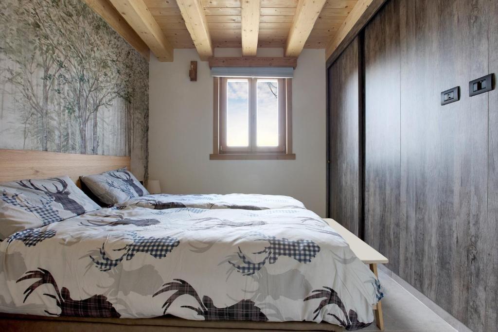 a bedroom with a bed and a window in it at Bellagio - Baita treeb Tivano in Bellagio